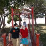 women wearing blue skirt and red sweater crossing the sharmar village bridge